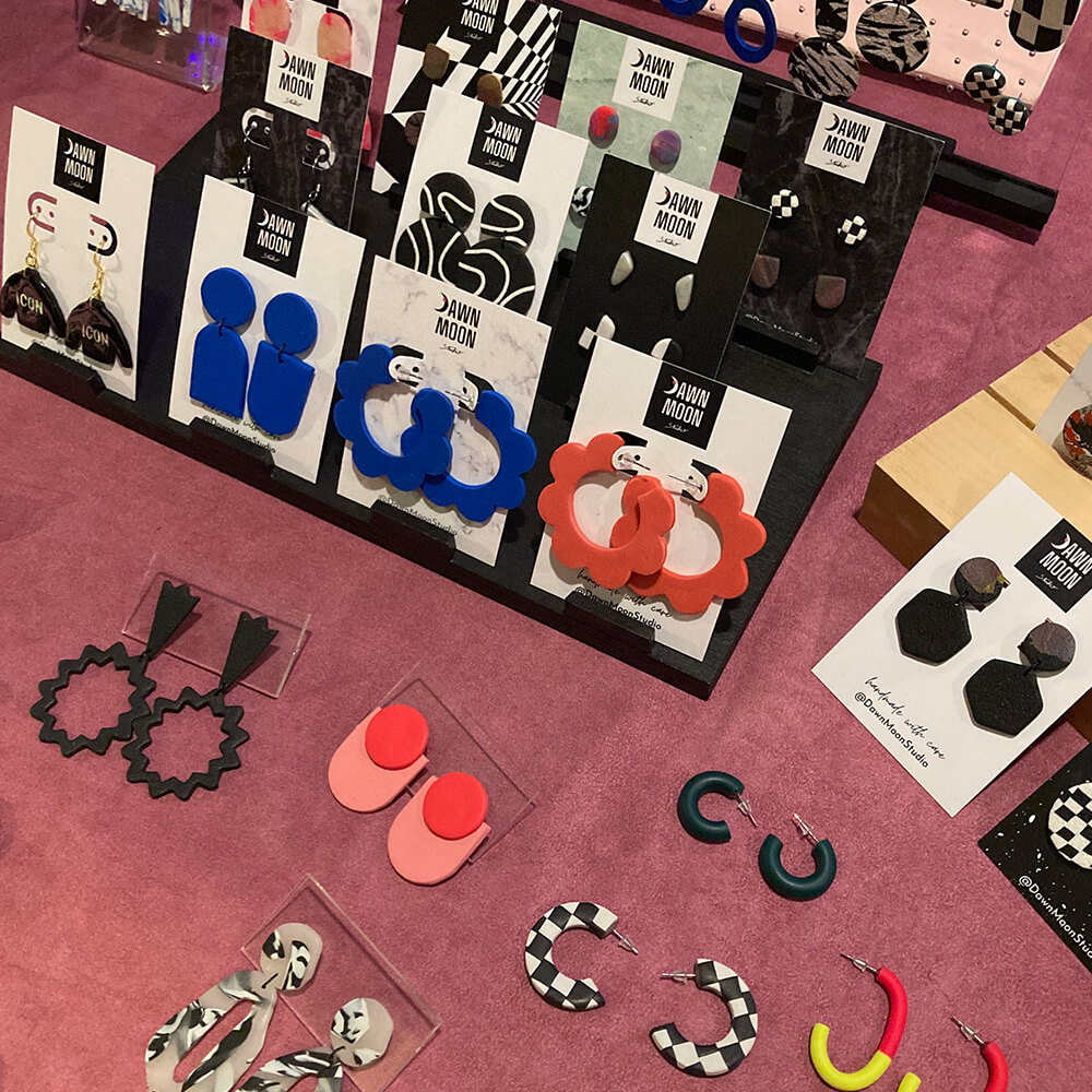 Close up of a vendor's table showcasing funky earrings